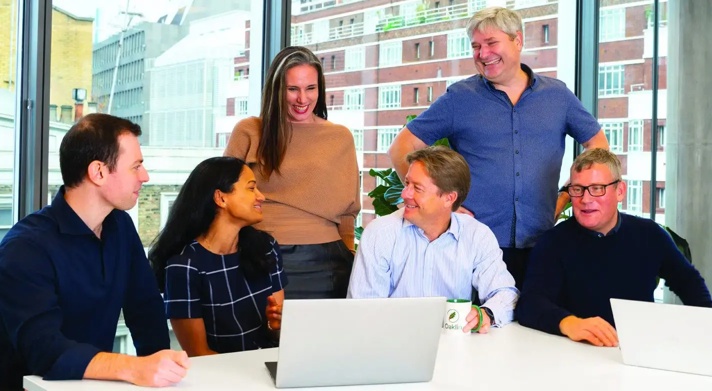 Oaklin consultants working together around a laptop